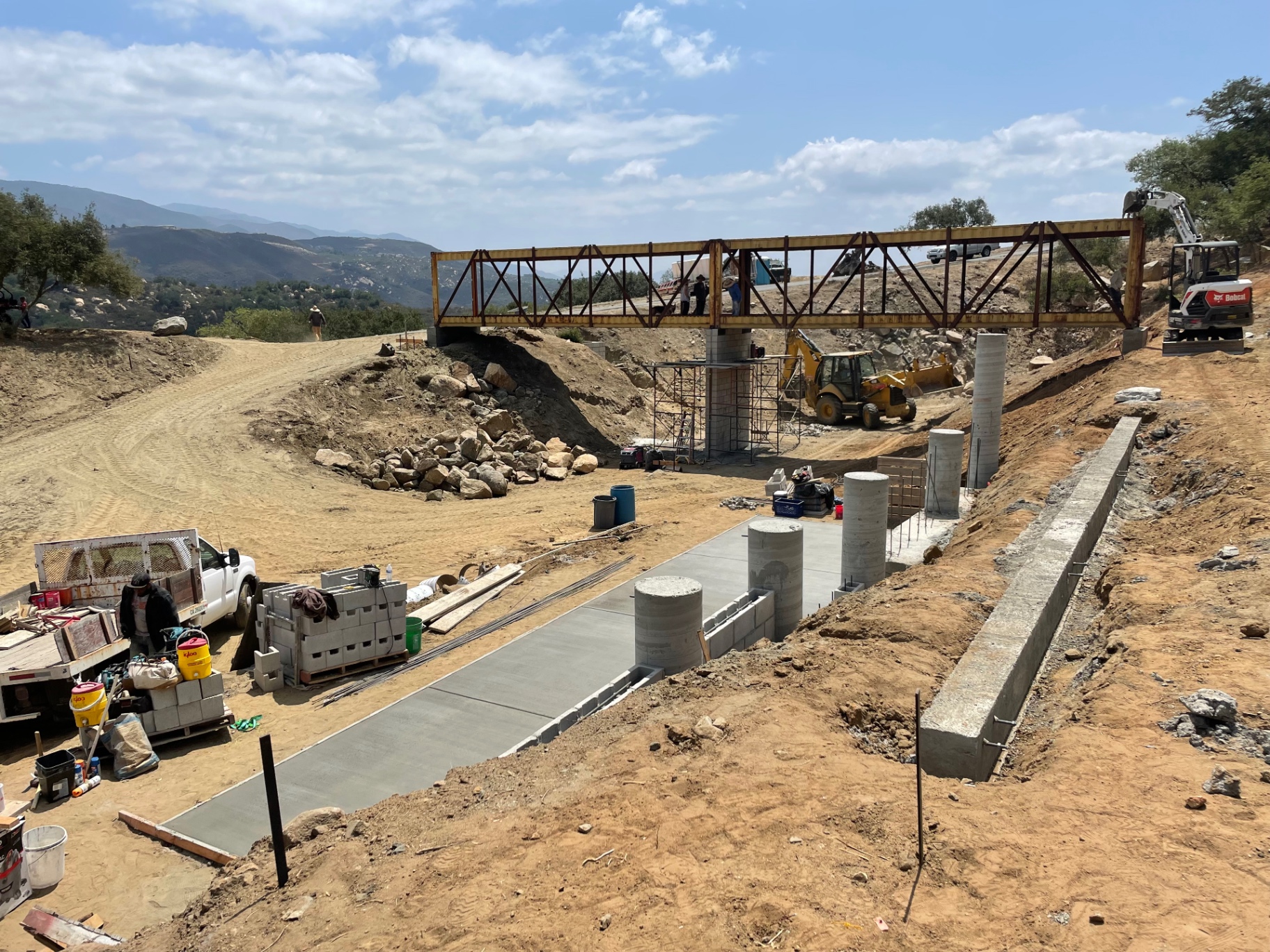 Bridge abutment, concrete pillars and flatwork on a hillside job site